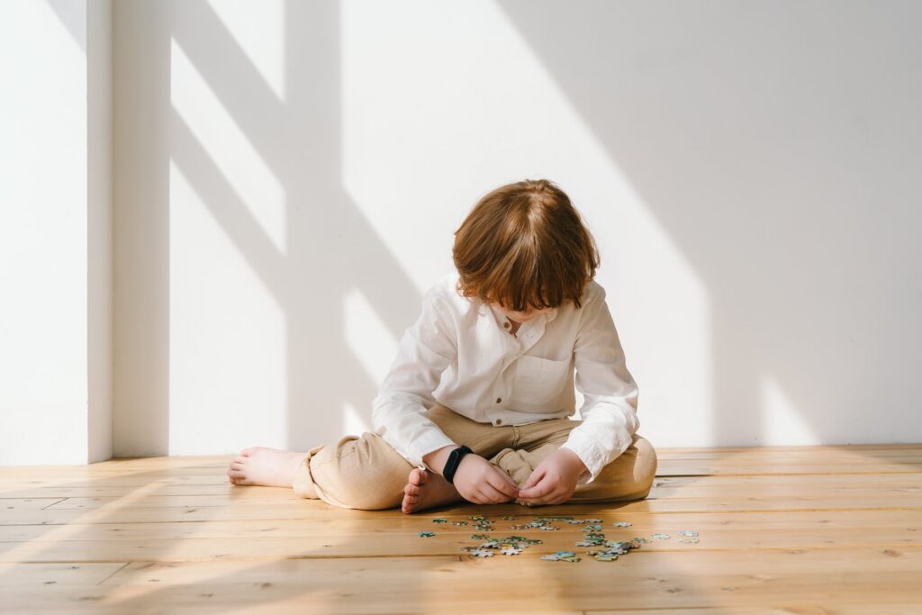 boy in white long sleeve shirt playing puzzle